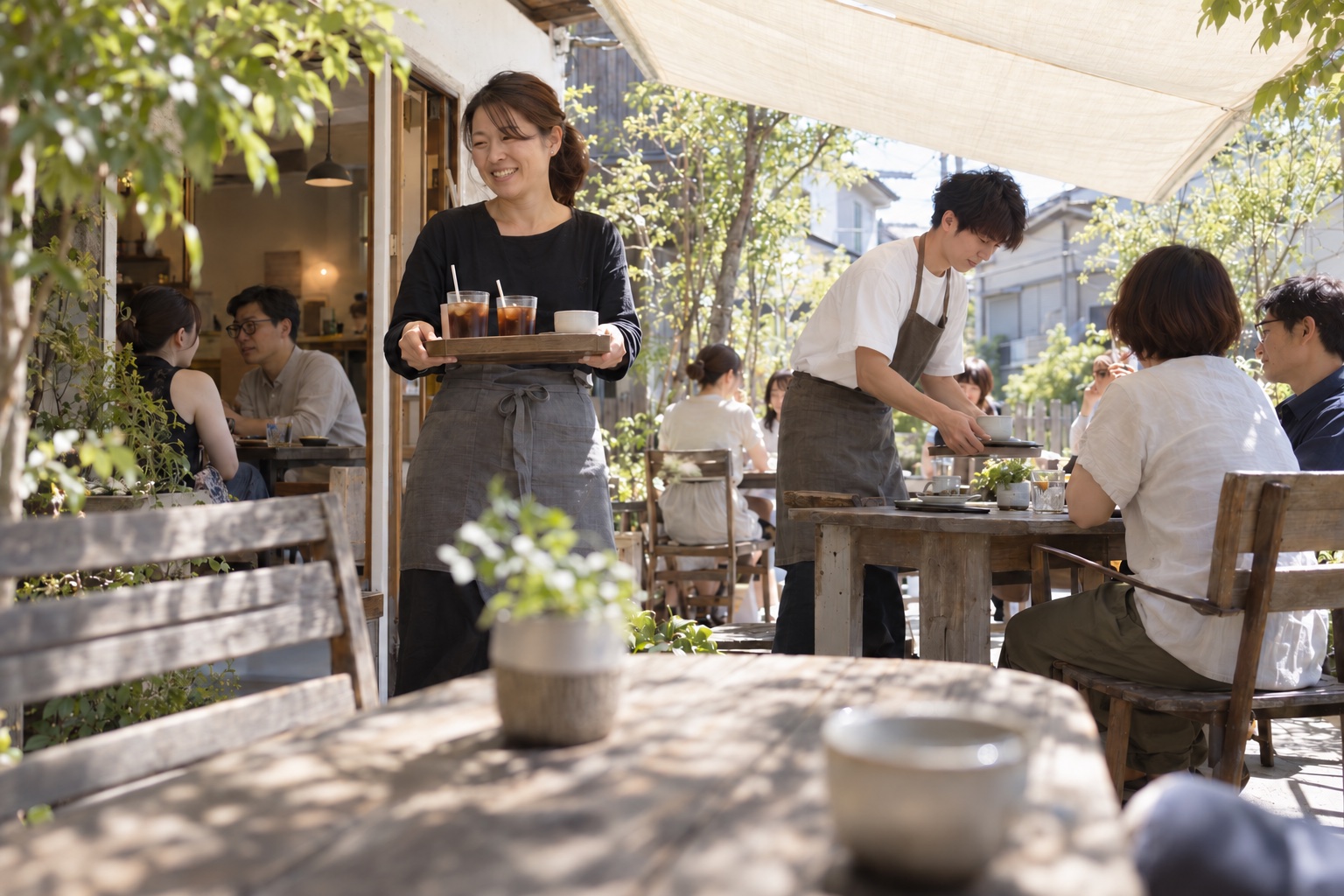 日差しのあるカフェのテラスで働くスタッフ。AI生成のイメージで、実際の画面・事例・提供内容を示すものではありません。